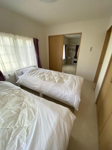 2 Betten in einem Hotelzimmer mit Spiegel in der Unterkunft ツナゲル青森安方annex in Aomori