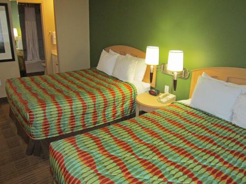 
a hotel room with two beds and two lamps at Extended Stay America Suites - Orlando - Lake Buena Vista in Orlando
