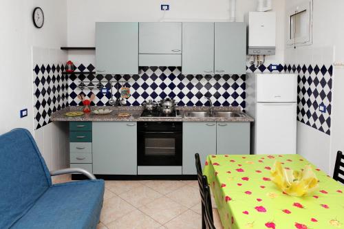 a kitchen with a table and a blue chair and a kitchen at Villa Adriana in Rosolina Mare