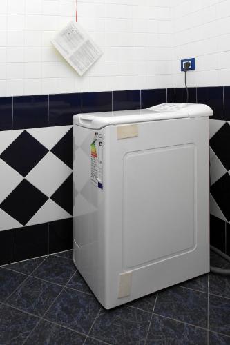 a washing machine in a bathroom with black and white tiles at Villa Adriana in Rosolina Mare