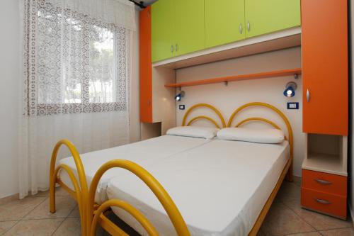 a bedroom with a bed with orange and green walls at Villa Adriana in Rosolina Mare