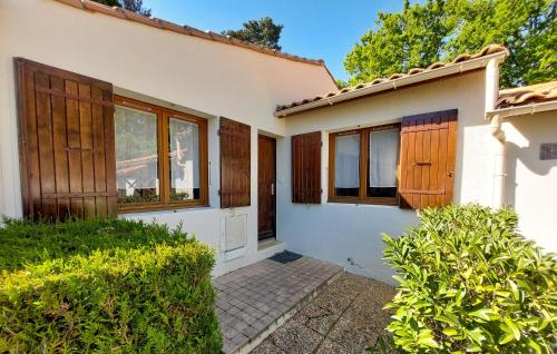 Cette maison blanche dispose de portes et de fenêtres en bois. dans l'établissement Amazing Home In Saint-Georges-De-Didon, à Saint-Georges-de-Didonne