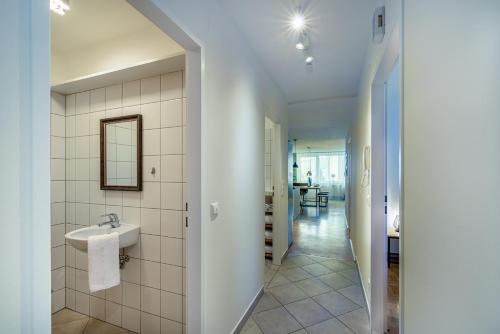 a bathroom with a sink and a hallway at Stadtapartments Luna by Cosy Homes in Villach
