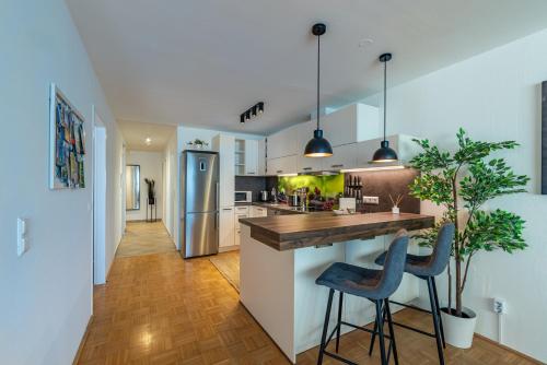 a kitchen with a counter and two stools at Stadtapartments Luna by Cosy Homes in Villach