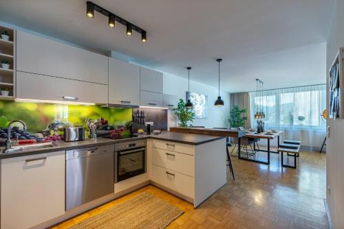 a kitchen with white cabinets and a dining room at Stadtapartments Luna by Cosy Homes in Villach