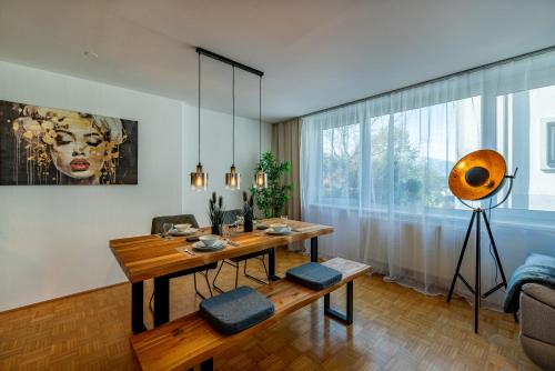 a living room with a table and a large window at Stadtapartments Luna by Cosy Homes in Villach