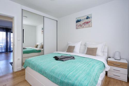 a bedroom with a large bed and a mirror at Apartment Wali in Nin