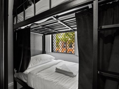 a black and white photo of a bunk bed at Sydney Pod Hotels - Darling Harbour in Sydney