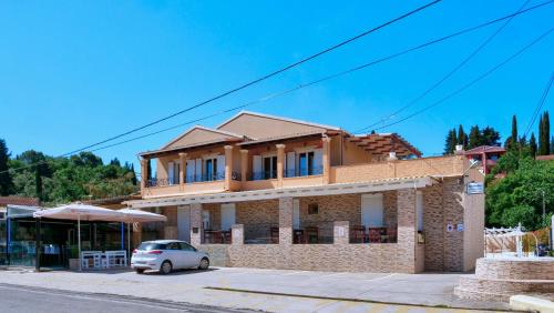 una casa con un coche aparcado delante de ella en Spiridoula's Apartments Corfu, en Perama