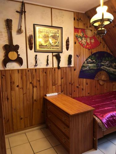 une chambre avec un lit et un mur en bois dans l'établissement Yufan, à La Ville-du-Bois