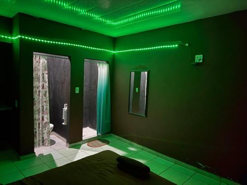 een groene kamer met een bed en een badkamer bij X-MOTEL VOSLOORUS in Vosloorus