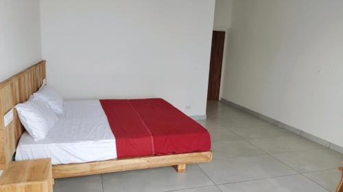a bedroom with a wooden bed with a red blanket at Mist View Resort Wayanad in Wayanad
