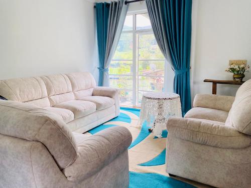 a living room with two couches and a window at Highest Village Bungalow in Nuwara Eliya