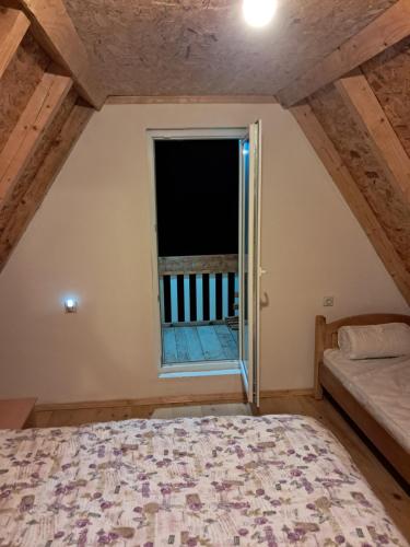 a bedroom with a bed and a window at Village House Djurovic in Pošćenje