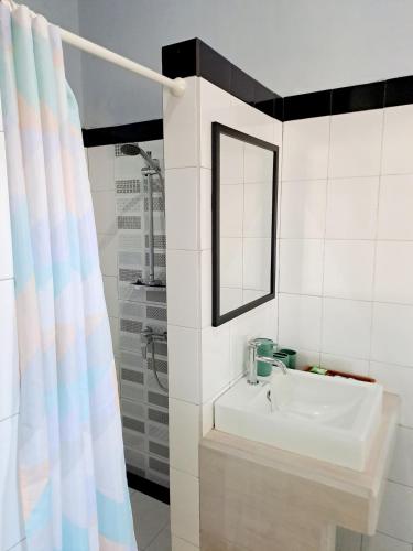 a bathroom with a sink and a mirror and a shower at Beach House Penida in Nusa Penida