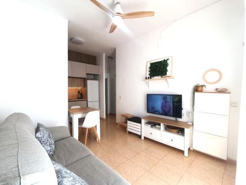 un soggiorno con divano e TV a schermo piatto di Apartamento Cabo de Palos - La Manga con Aire Acondicionado a Cartagena