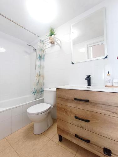 a bathroom with a toilet and a sink and a mirror at Apartamento Cabo de Palos - La Manga con Aire Acondicionado in Cartagena