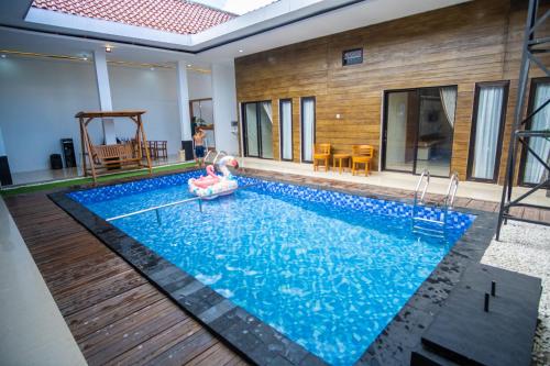 a swimming pool in a house with a pool noodle in the middle at Ranya Homestay in Purwokerto