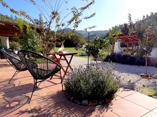 a patio with a table and chairs and plants at Nova Alofa holiday home in Monchique