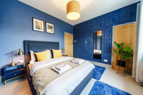 sypialnia z niebieskimi ścianami i dużym łóżkiem w obiekcie Family House Garden Netflix Games FreeParking w Cardiff