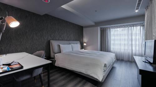 a bedroom with a bed and a desk and a television at 安庭台北商旅 in Taipei
