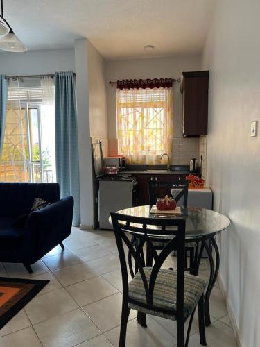 a living room with a table and a kitchen at Vero Homes in Buwate