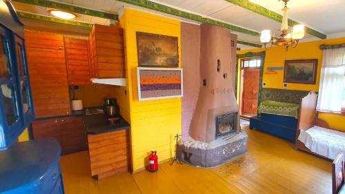 a room with a yellow wall with a fireplace at Czworaki Dworskie - Kiermusy in Kiermusy