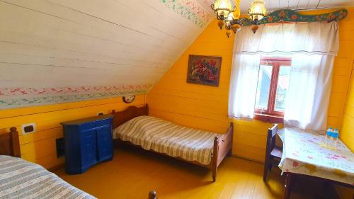 a room with two beds in a yellow room at Czworaki Dworskie - Kiermusy in Kiermusy