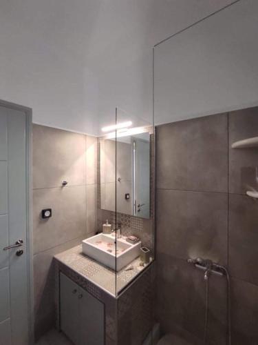 a bathroom with a sink and a mirror at SIFNAIOU TRADITIONAL Houses 1 & 3 in Parikia