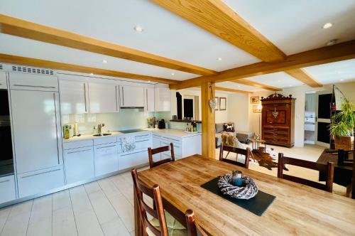 Il comprend une cuisine et une salle à manger avec une table en bois. dans l'établissement Chalet JOLUKSI - mit Sprudelbad, à Grindelwald