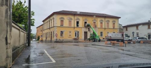 a yellow building with a crane in front of it at Stanza privata in dimora storica in Paderno