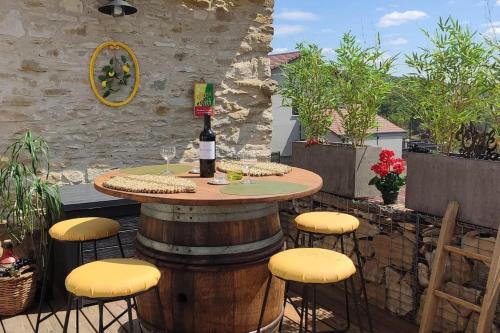 - une terrasse avec une table et une bouteille de vin dans l'établissement Jacuzzi au Lemon Tree et charme des pierres dorées, à Panossas