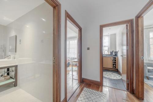 uma casa de banho com uma porta de vidro que leva a uma sala de estar em Stunning Flat Next To Hyde Park em Londres