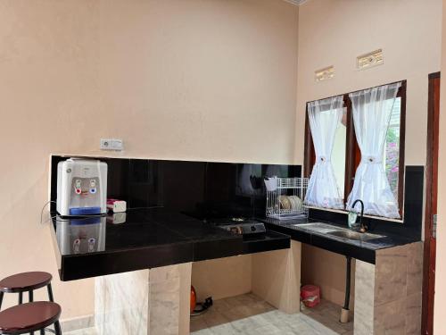 a kitchen with a black counter and a sink at NADELS HOMESTAY SYARIAH in Gadut