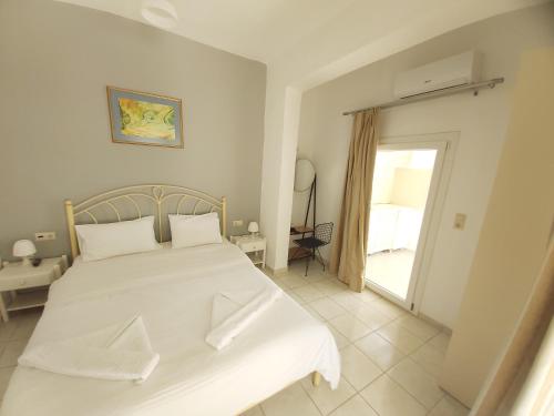 a bedroom with a large white bed and a window at Antonios 1 in Matala
