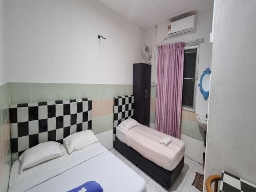una piccola camera con due letti e un lavandino di OYO 90972 Jj Homestay a Miri