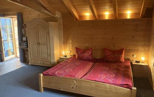ein Schlafzimmer mit einem großen Bett mit roten Kissen in der Unterkunft Ferienwohnungen Bernie Schmid in Sonthofen