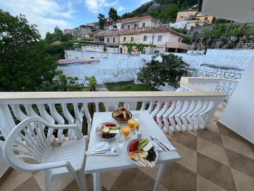 uma mesa branca com um prato de comida numa varanda em Vila Taga Guesthouse em Krujë