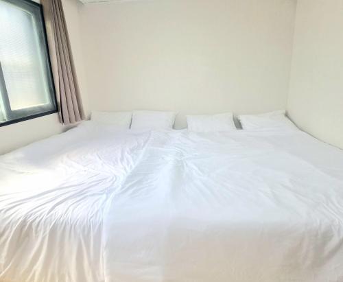 a white bed in a room with a window at Stay Cheongnyang in Seoul