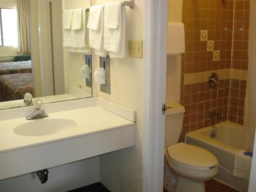 a bathroom with a sink and a toilet and a mirror at Perimeter Inn - Athens in Athens