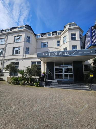 a large white building with a sign that reads the trumpville at The Trouville Bournemouth in Bournemouth