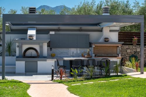 a kitchen with an outdoor kitchen with a grill at Lilium Villa, summer aroma, By ThinkVilla in Perama