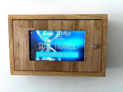 un cartello in una scatola di legno su un muro di Time Travel a Saint-Rambert-sur-Loire