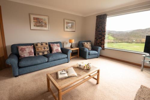 a living room with two blue couches and a coffee table at Lang Parrock, Little Langdale in Little Langdale