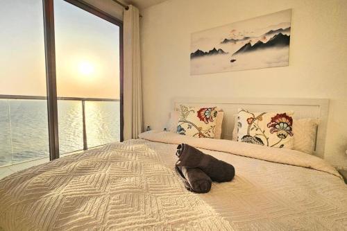 a stuffed animal laying on a bed in a bedroom at Luxury Ocean Front Apartment in Ras al Khaimah