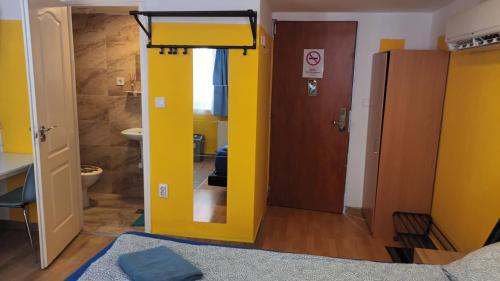 ブダペストにあるDeniz Guesthouseの黄色のドアとトイレ付きのバスルーム