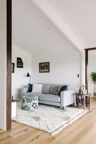 a white living room with a couch and a table at Heartwood Farm Byron Bay Luxury Farm Stay in Federal
