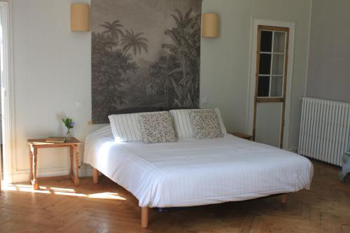 Chambres d'Hôtes Château de Martragny في Martragny: سرير بشرشف ووسائد بيضاء في الغرفة