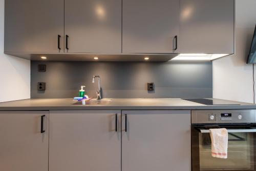 a kitchen with white cabinets and a sink at Uppsala Hotel Apartments in Uppsala