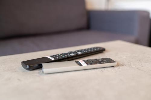 two remote controls sitting on top of a table at Uppsala Hotel Apartments in Uppsala